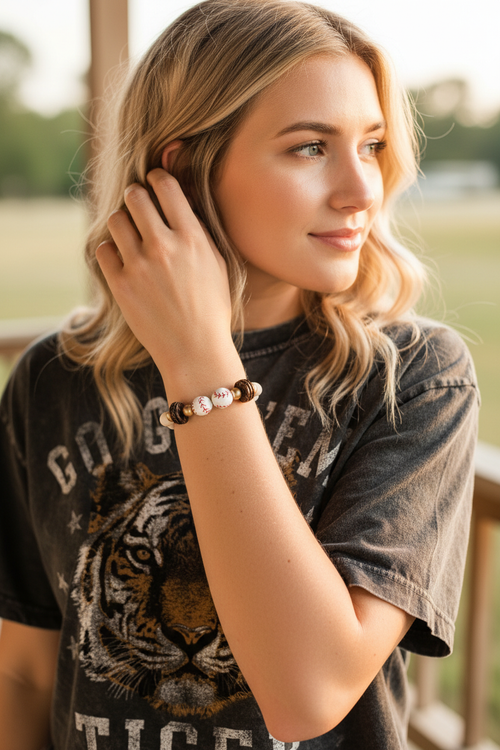 Close-up of baseball bracelet as woman brushes hair back