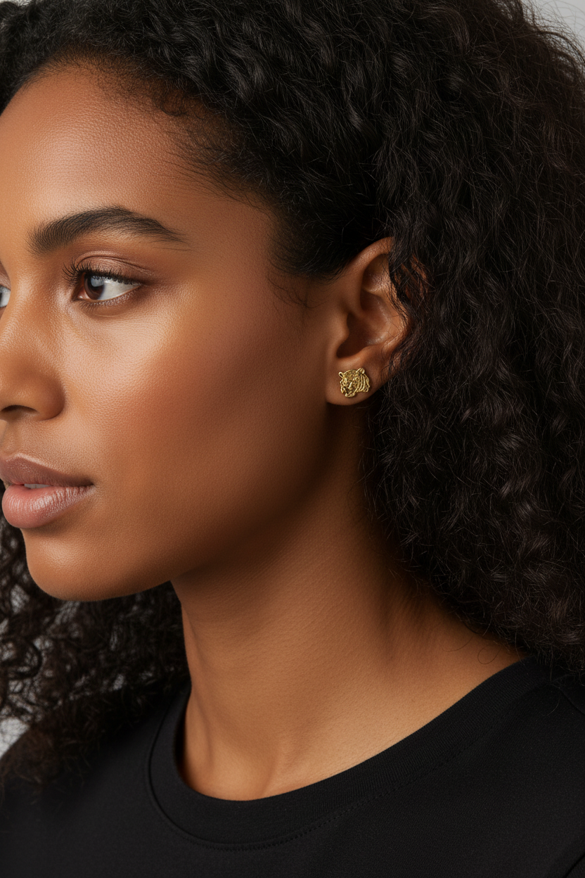 Extreme close-up of woman wearing tiny gold tiger head studs
